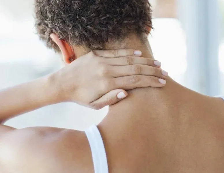 Woman rubbing back of neck in pain