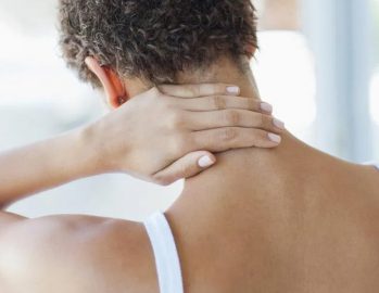 Woman rubbing back of neck in pain