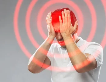 Man holding his head as though he is experiencing a migraine