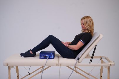 Woman uses PEMF therapy Mat with the TeslaFit Duo for Back Treatment (photo 1)