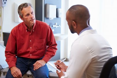 Doctor talks to his patient and takes notes